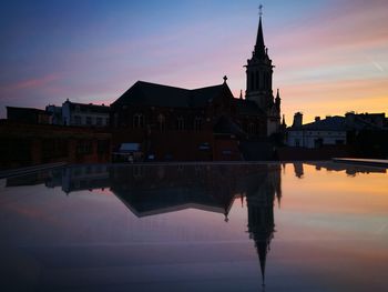 Reflection of buildings in lake during sunset