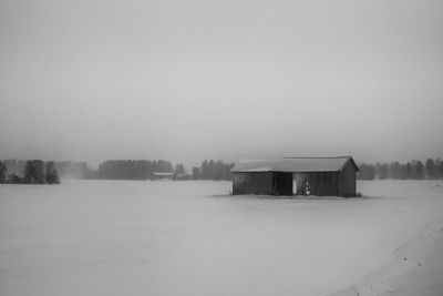 A snow storm rages over the fields and barn houses. the snow flies all over the place on the fields.