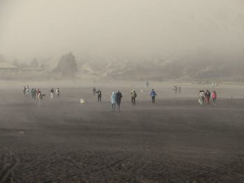 People on field during foggy weather