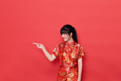 Woman standing against red background