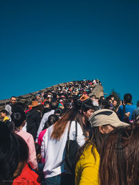 Group of people standing against clear blue sky