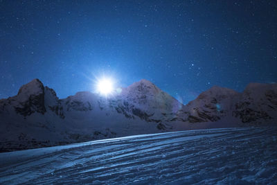 Scenic view of snow covered mountains against sky at night