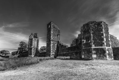 Low angle view of old building on field against sky