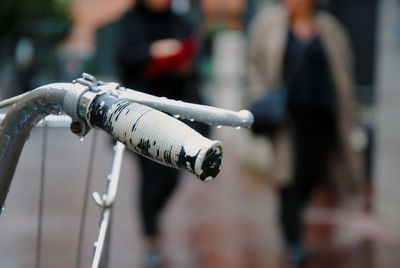 Close-up of wet bicycle handle on street