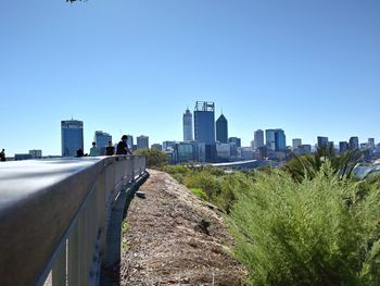 Panoramic shot of city buildings against clear blue sky