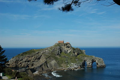 Rock formations by sea against sky