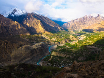 Scenic view of river and mountains against sky