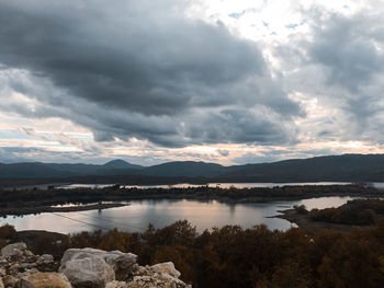 Scenic view of lake by mountains against sky