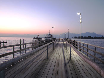 Pier on sea against clear sky during sunset