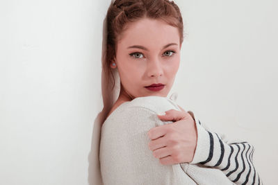 Portrait of young woman against white background