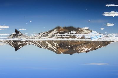 Scenic view of frozen lake against clear blue sky