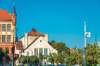 Panoramic view of buildings in city against clear blue sky