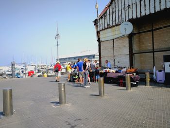 People on street in city against clear sky