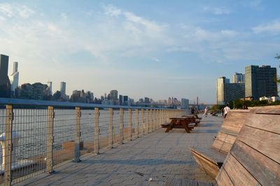 City at waterfront against cloudy sky