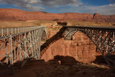 Bridge over river against cloudy sky