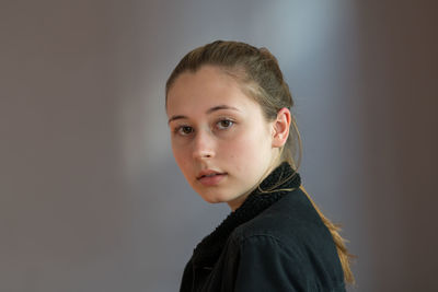 Close-up portrait of a serious young woman over white background