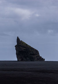 Rock formation on sea against sky