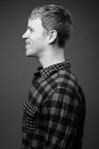 Portrait of young man looking away against black background