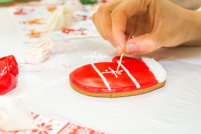 Midsection of person holding ice cream on table