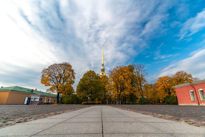 View of trees and buildings against cloudy sky