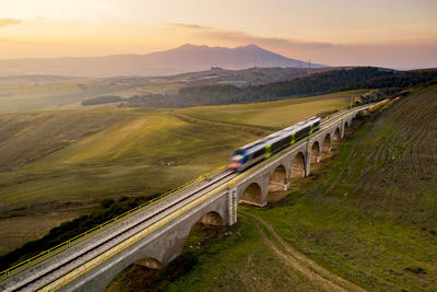 High angle view of train on rrailway against sky at the sunset