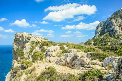 Rock formations by sea against sky