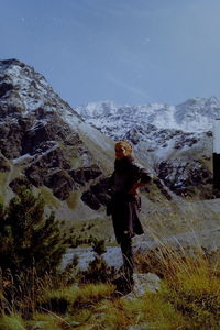 Woman standing on mountain against sky