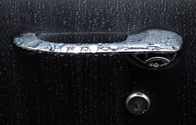 Full frame shot of wet car door handle during rain