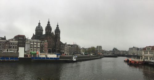 River by buildings against cloudy sky