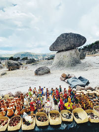 Group of people on rock by sea against sky