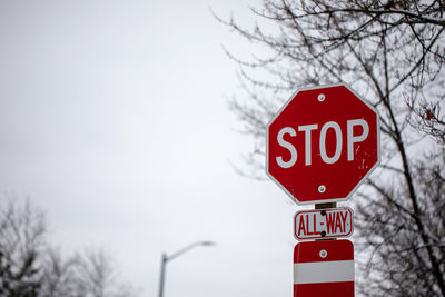 Road sign against sky during winter