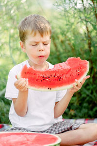 Boy eating watermelon white t-shirt. picnic with watermelons. 