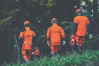 Men walking in the forest holding a chainsaw and garden tools. lumberjacks gardeners working outdoor
