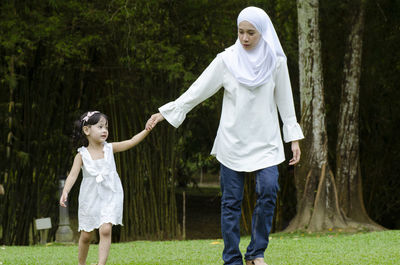 Full length of a woman standing against trees