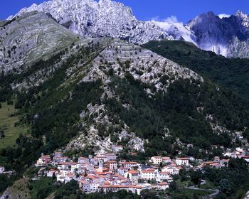 Aerial view of townscape by mountain against sky