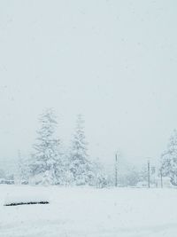 Snow covered field against clear sky