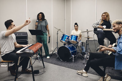 Multiracial men and women rehearsing together in classroom