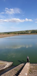 Man looking at lake against sky