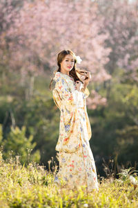 Woman standing on cherry blossom tree