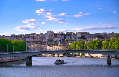 Bridge over river against buildings in city