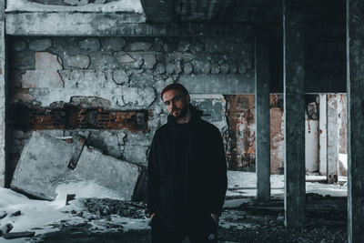 Portrait of young man standing in abandoned building