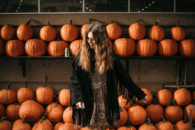 Woman standing against pumpkins at market