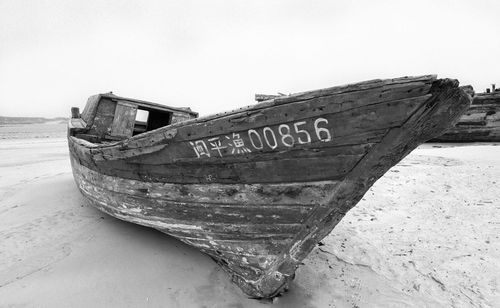 View of abandoned boats on beach against clear sky