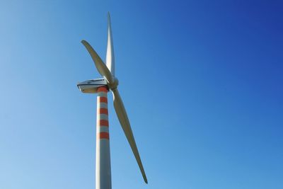 Low angle view of windmill against clear blue sky