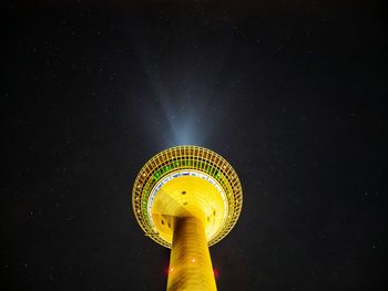 Low angle view of illuminated tower against sky at night