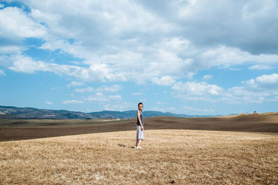 Side view of woman standing on grassy field
