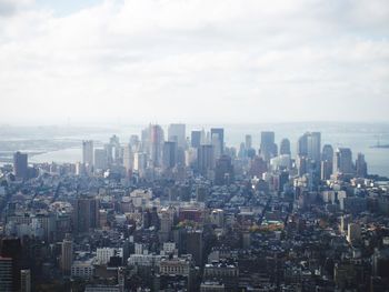 Aerial view of buildings in city against sky