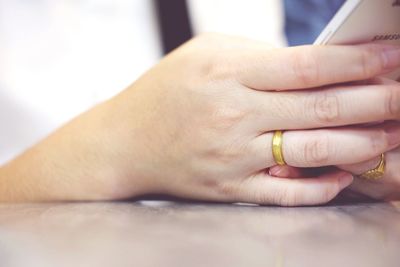 Cropped hands using mobile phone at table