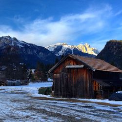 House by mountain against sky during winter