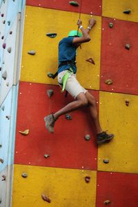 Low angle view of teenage boy climbing wall